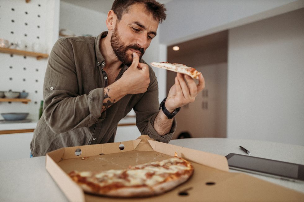man in the kitchen eating unhealthy food