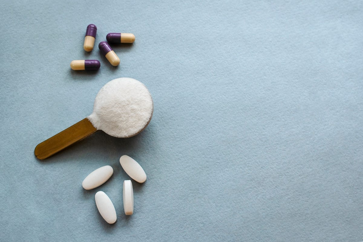 Three types of collagen in tablets and powder capsules on a gray background