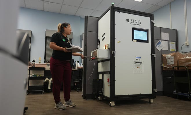 Using a new automated dose assembly machine, Registered Nurse Siv Mao removes a tray of methadone doses that will be dispensed to people with opioid use disorders. CompDrug made history by being the first opioid treatment program to go live using Zing, which assembles doses automatically. The innovative machine offers the opportunity to reduce human error, assemble drug doses at a rapid pace, and allow nursing staff to focus on direct patient care.